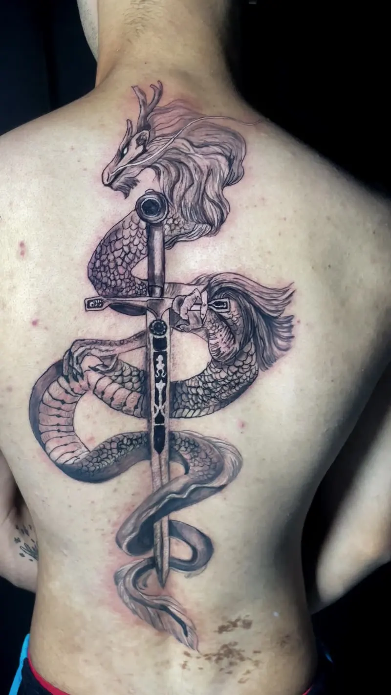 Tatuagem de dragão e cobra com espada nas costas, trabalho do tatuador que atende Várzea Grande