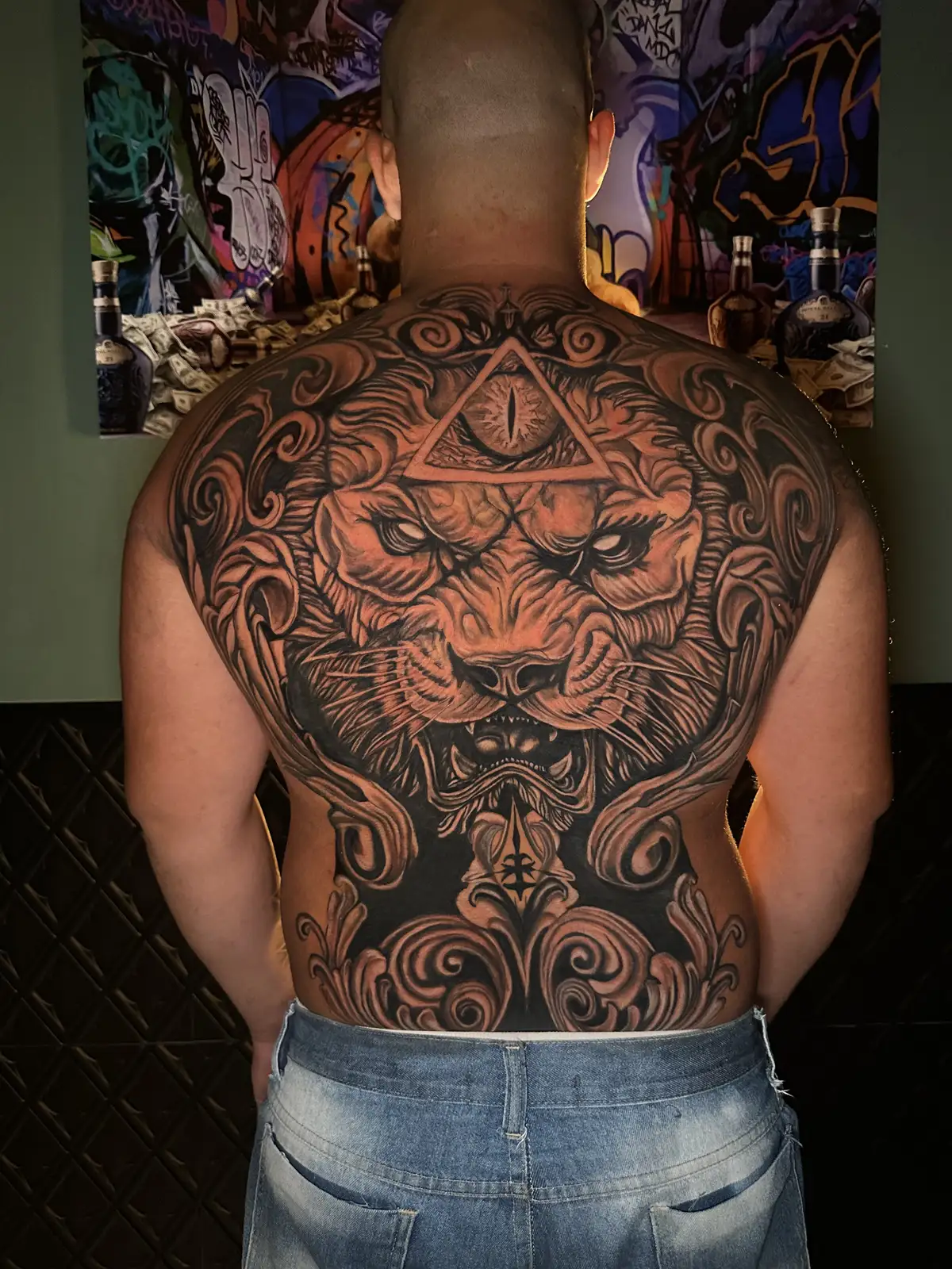 Tatuagem grande de leão em realismo fechando as costas inteiras