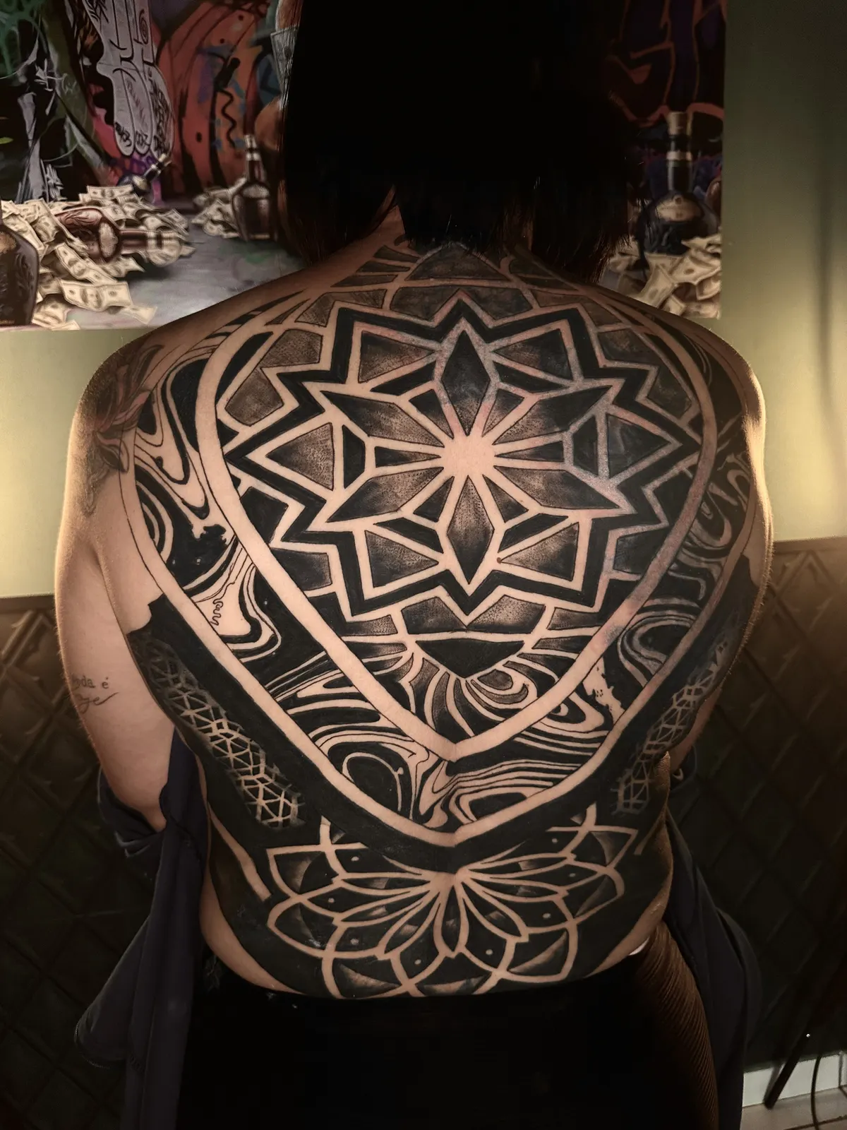 Tatuagem de mandala geométrica em blackwork nas costas, feita no estúdio Caliaro Art em Cuiabá