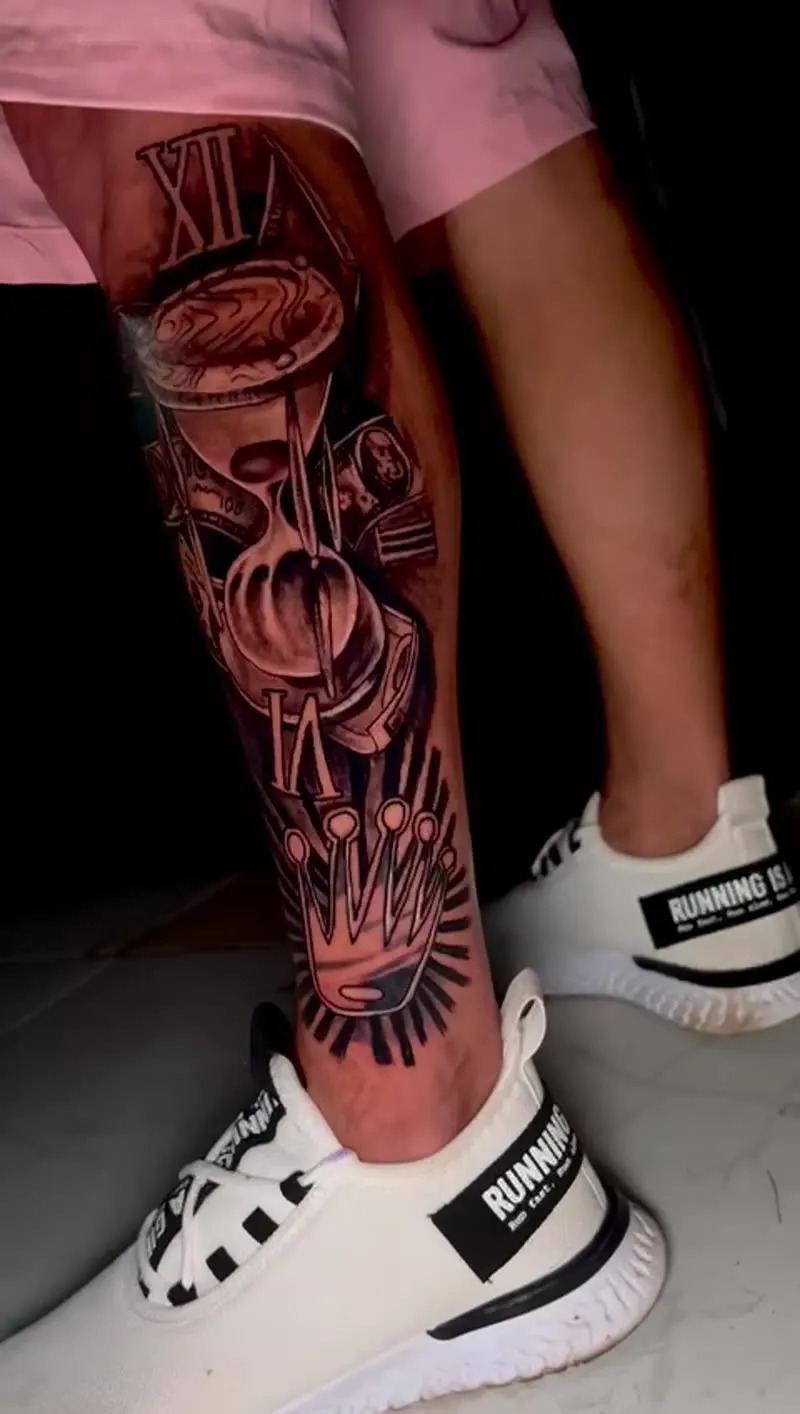 Tatuagem de relógio e ampulheta com volume tridimensional na panturrilha, feita em Cuiabá